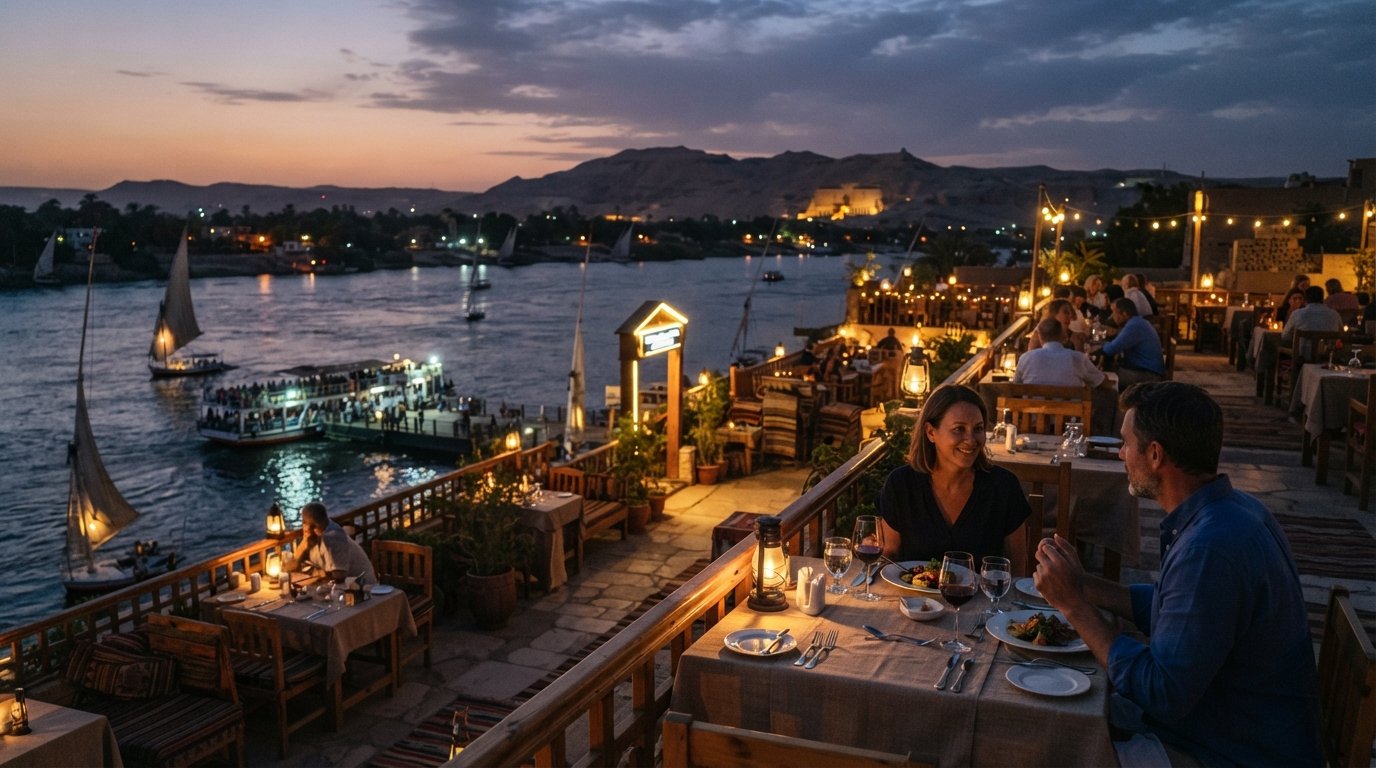 Terrazza del Sunflower Restaurant vicino all'approdo del traghetto al crepuscolo, con il Nilo sotto, tavoli apparecchiati per cena e il cielo della West Bank che sfuma sul fiume